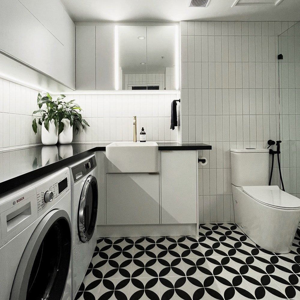 Black and white geometric tile black countertop bathroom designed by Hue and Space Interior Design