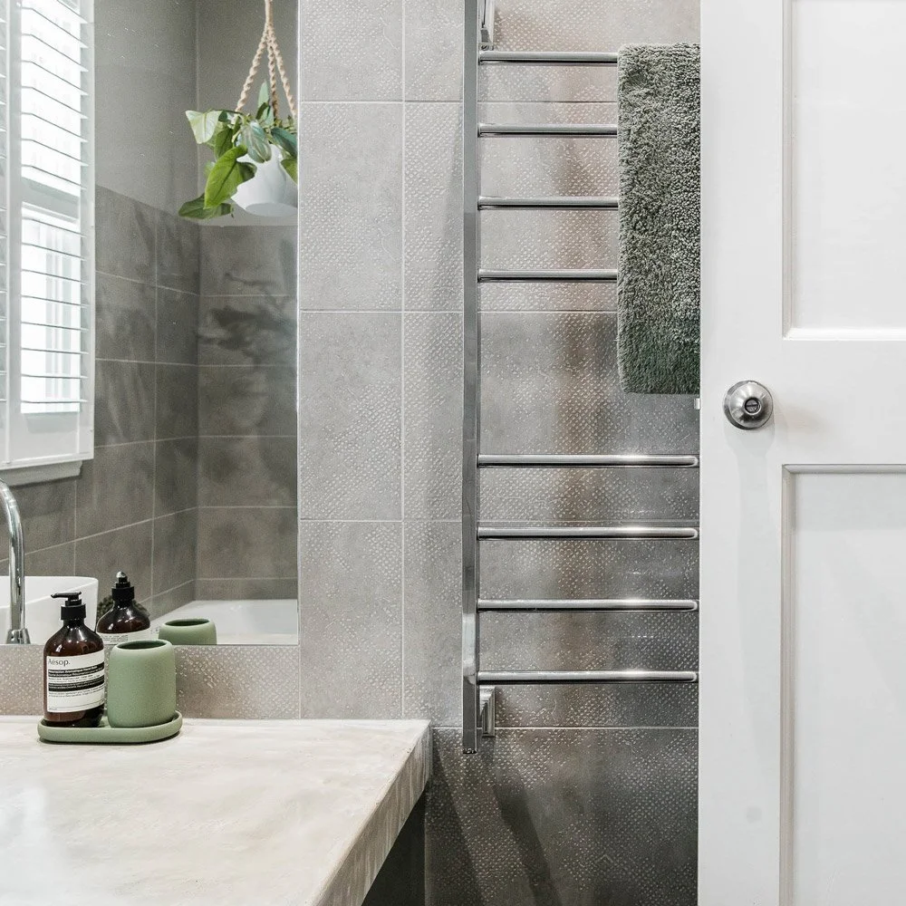 Bathroom vanity with heated chrome towel rail next to it