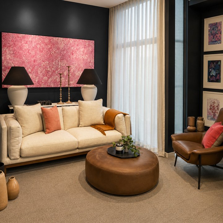 Cosy living room design for a room with very little natural light. Focus on dark blue walls bright pink indigenous art and a pale sofa with ochre and rust decor