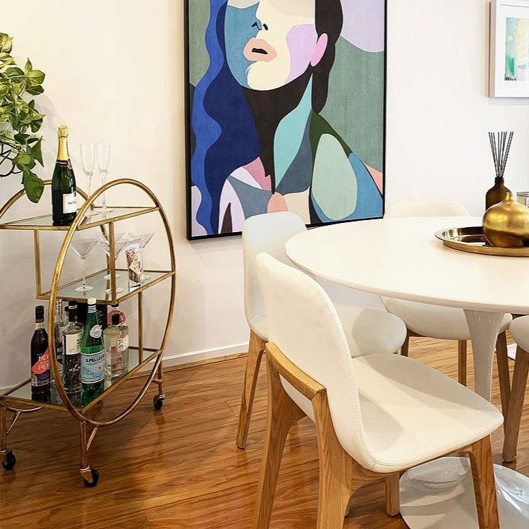 Bright art work behind a white table and chairs in a dinging space designed by Hue and Space Interior Design