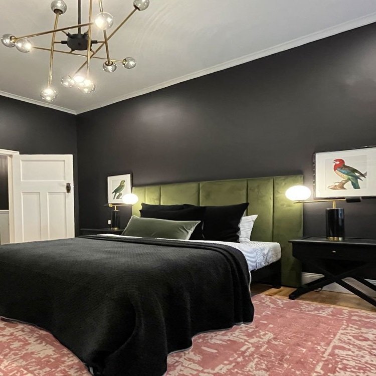 Dark grey bedroom walls with large queen size bed and Satelite chandelier