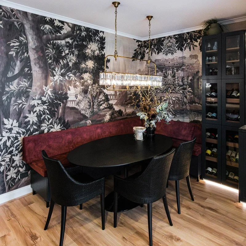 Bold velvet banquette seating around balck dining table and black wicker chairs
