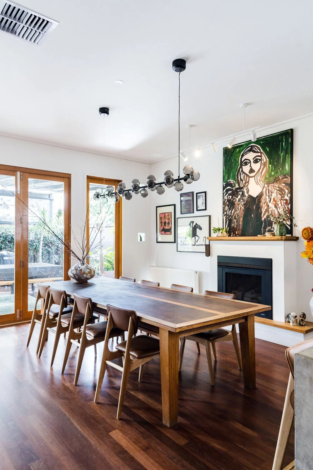 dining room table and chairs with linear pendant and large art