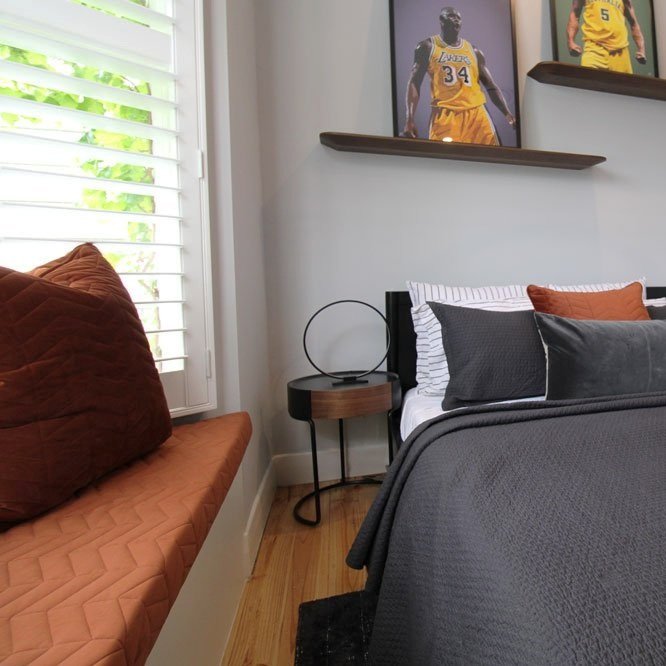 Window seat with custom upholstery and shelving above a bed in a boys bedroom designed by Hue and Space Interior Design