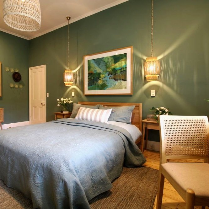 Teenage girls bedroom with sage walls and rattan pendant lights designed by Hue and Space Interior Design