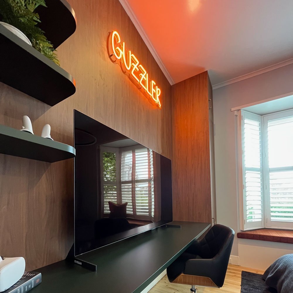 Custom joinery with neon sign and TV designed by Hue and Space Interior Design