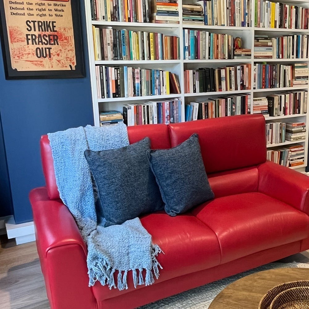 Red leather sofa is the focus of this living room designed by Hue and Space Interior Design