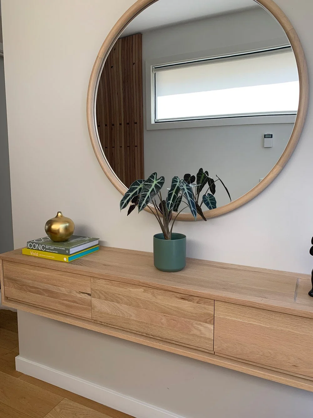 round timber framed mirror above timber floating console