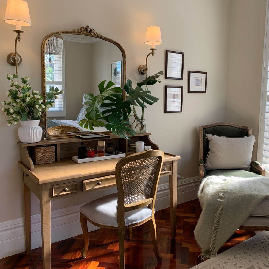 Brass sconces above a French Provincial dressing table