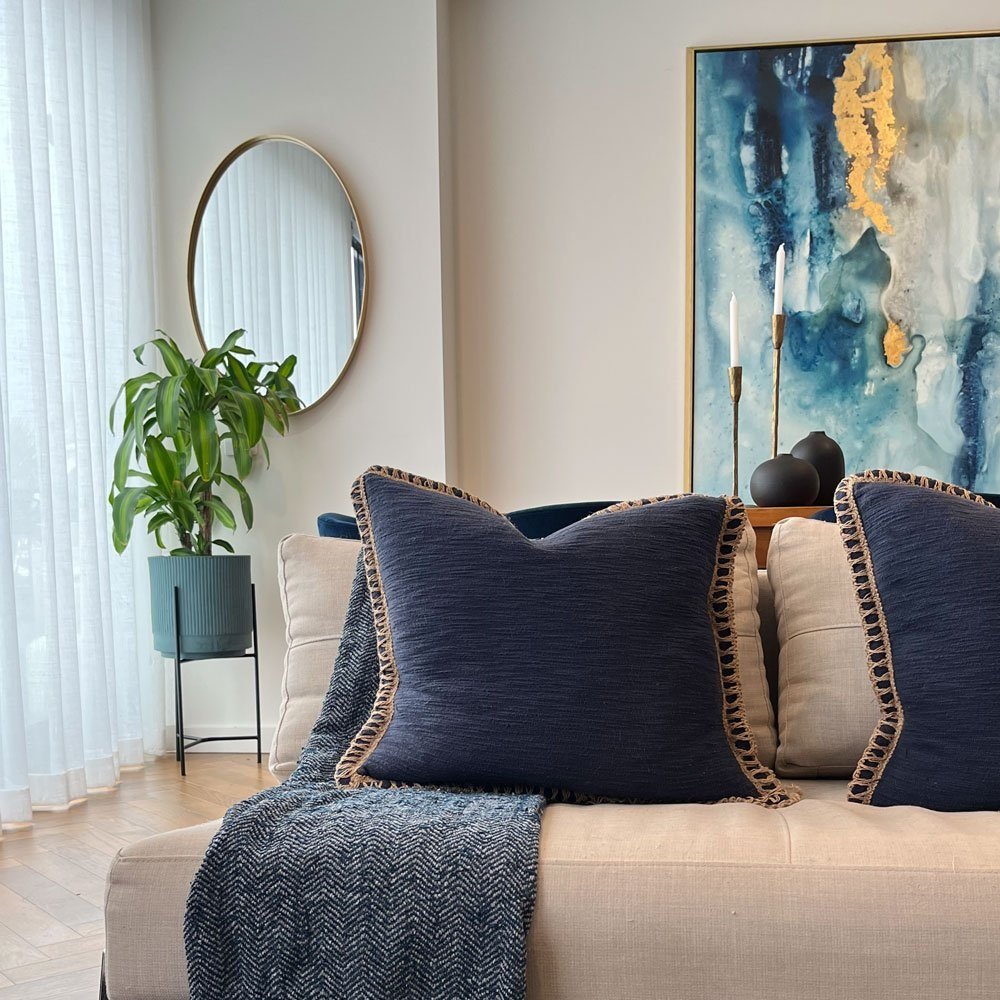 Comfortable sofa with blue cushion and throw in a living room designed by Hue and Space Interior Design