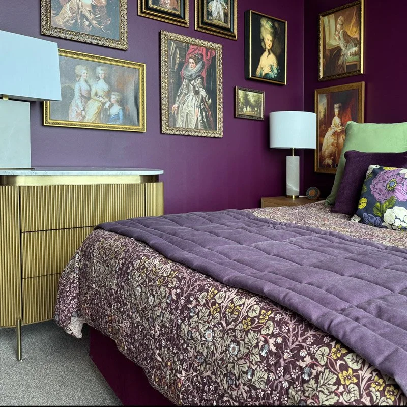 Rich purple fabrics, with gold framed art and apple green accents.
