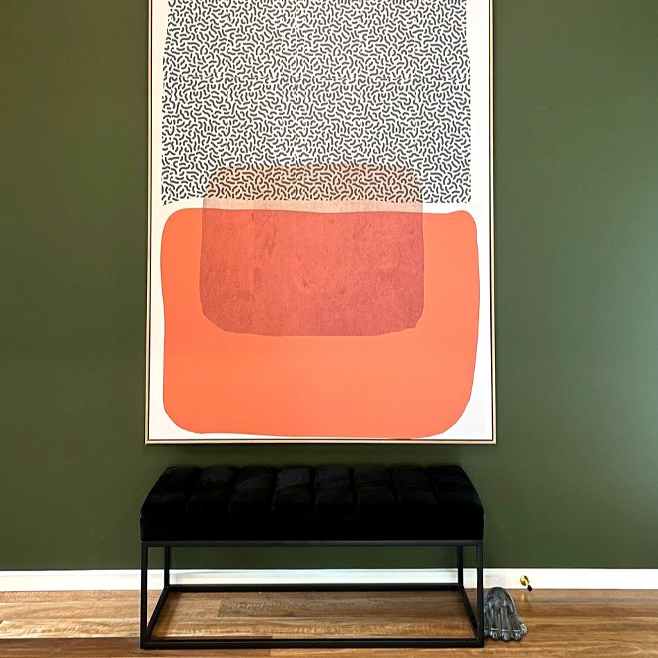 Bright orange white and black art print sits abpve black velvet bench in an entry made over by Hue and Space Interior Design