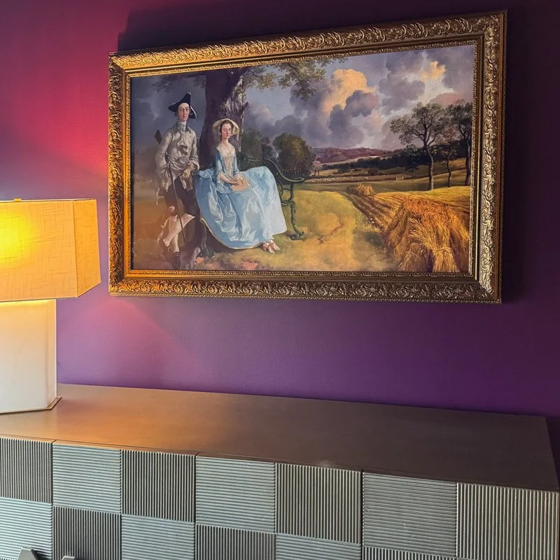 Frame TV with gilded frame over a gold texted buffet