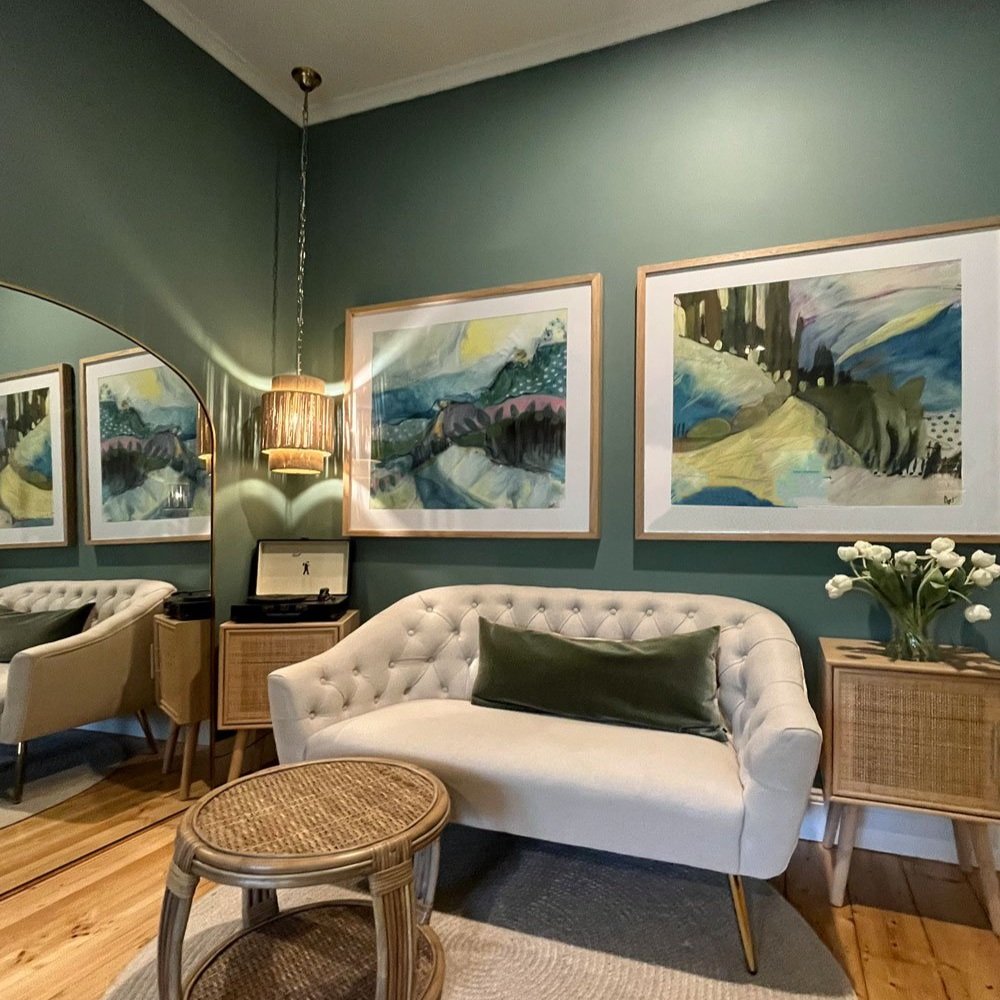 Record player on rattan side table next to small scale sofa and rattan coffee table, sage walls and colourful art, teenage girls bedroom designed by Hue and Space Interior Design