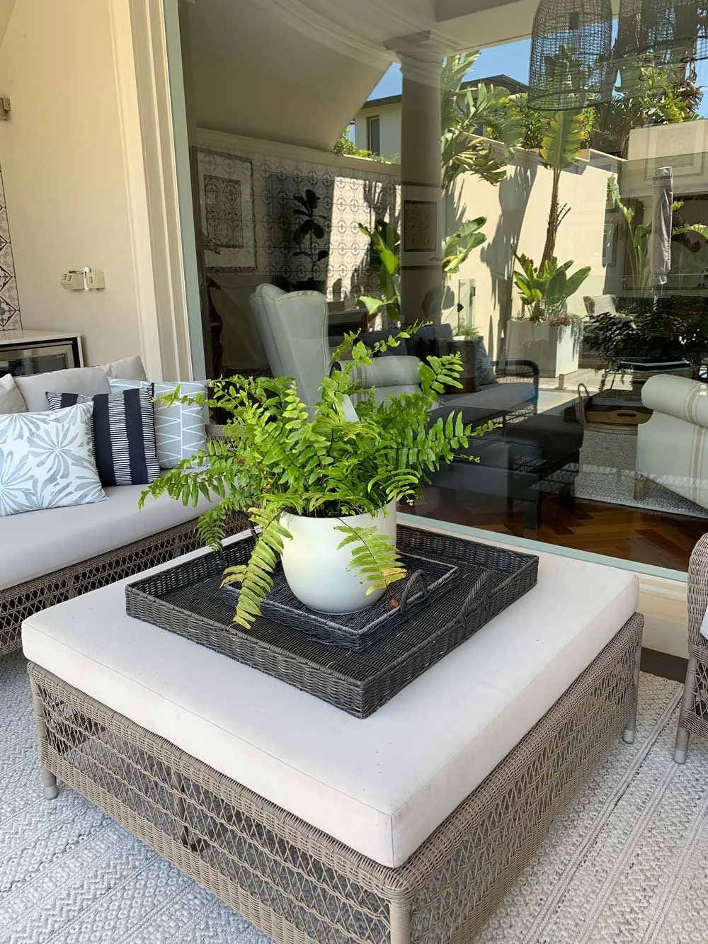 Outdoor ottoman rug and sofa with a view inside to the living room