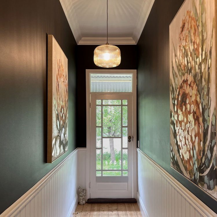 Hallway painted in dark grey with white panelling, wainscoting and hand blown glass pendant lights designed by Hue and Space Interior Design