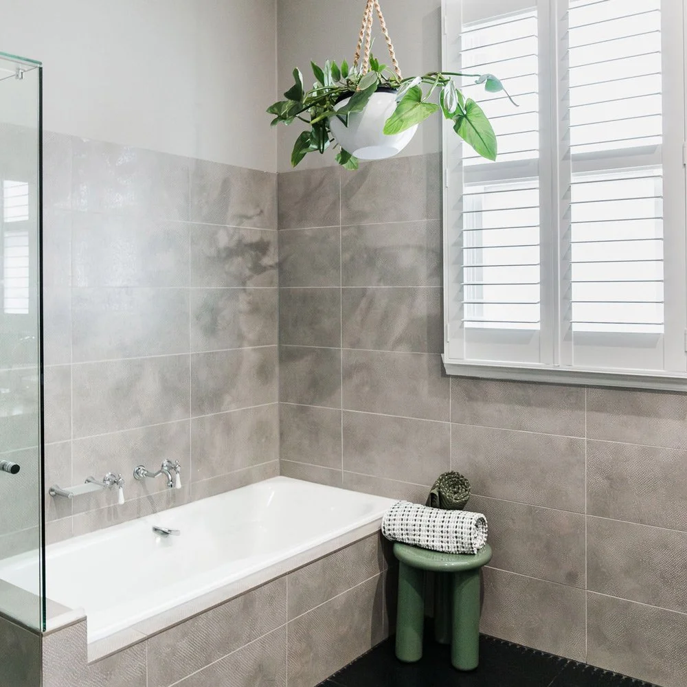 Bathroom with large bath and large scale grey tiles