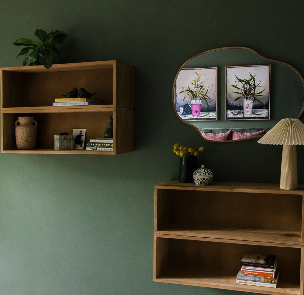 Hanging bookshelf boxes on green bedroom wall