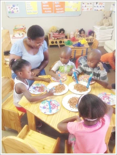 Teacher Maria works with three year olds on developing fine motor skills. Photo courtesy of Mary Jo Jean-Francois.