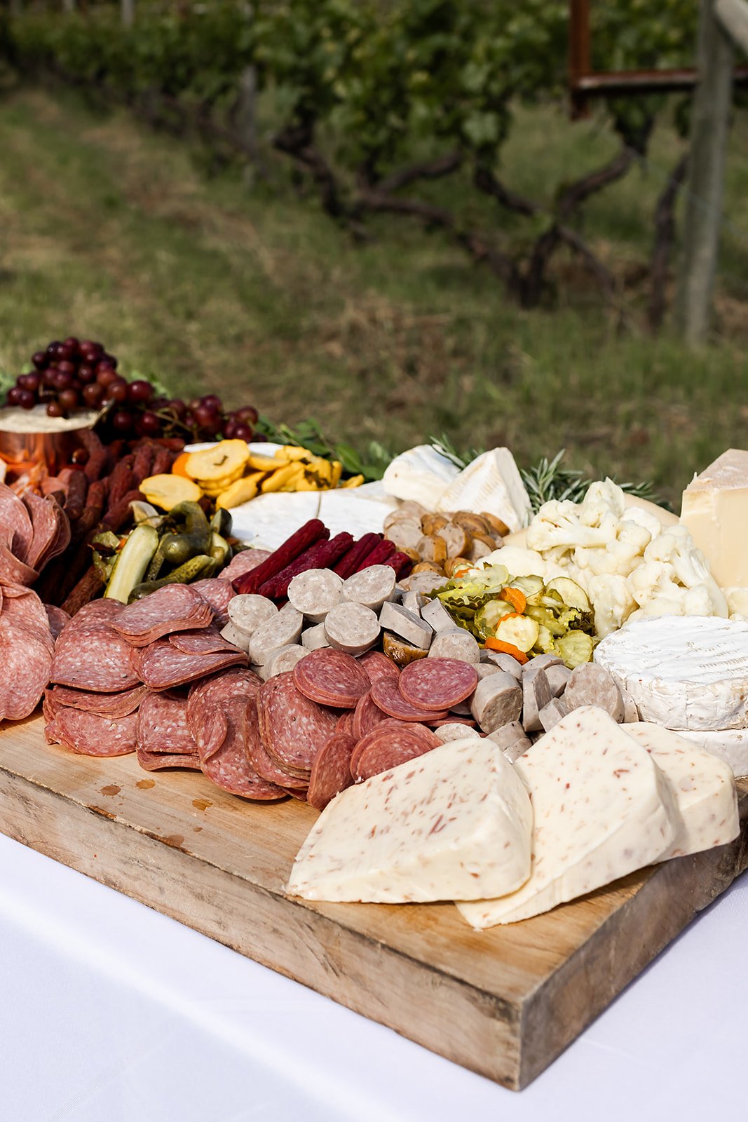 grazing board display of charcuterie and cheese with dried and fresh fruits, picked vegetables and spreads