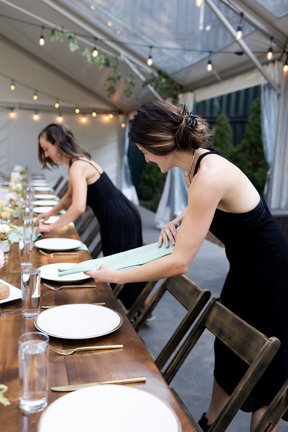 women of art de cuisine catering arranging table settings at outdoor wedding
