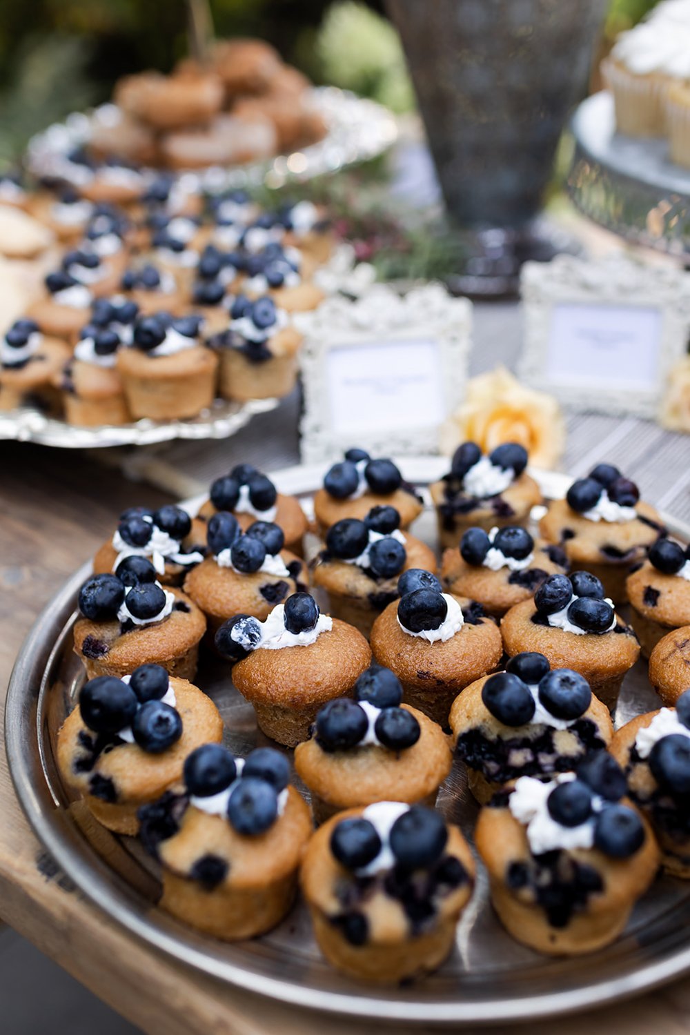 mini blueberry muffins topped with whipped cream and fresh berries