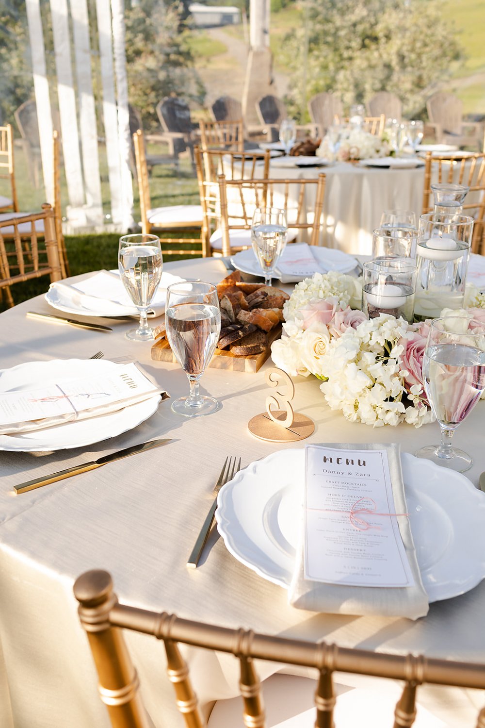 white with gold accent table settings at wedding featuring menu by art de cuisine catering