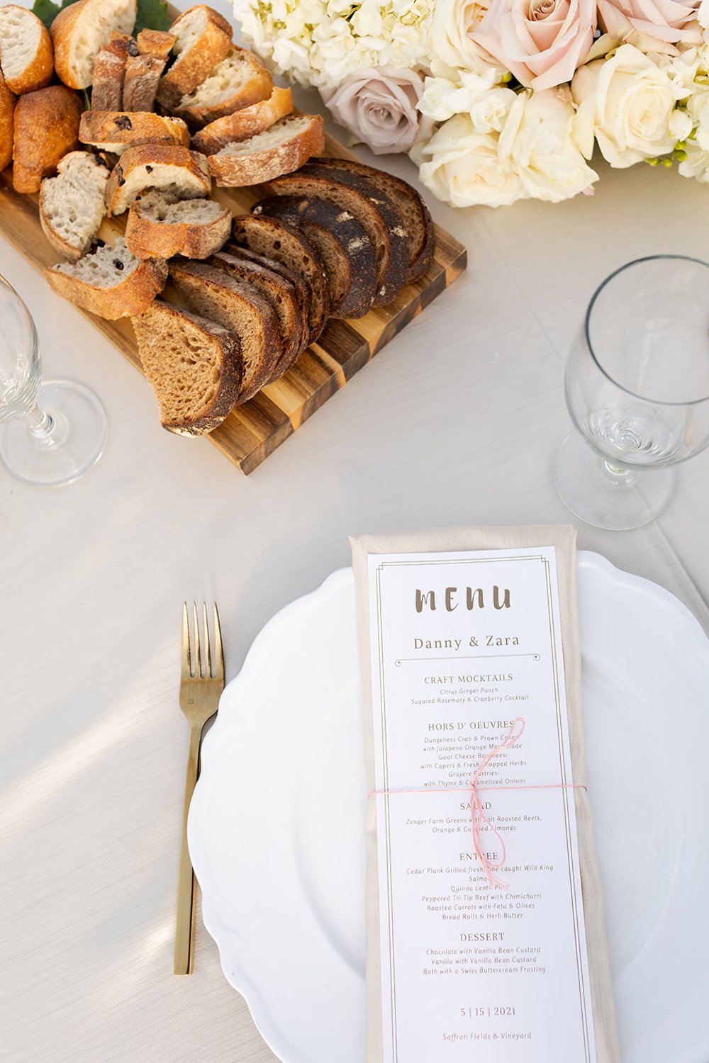 spring style wedding table settings with sliced artisan breads and menu by art de cuisine
