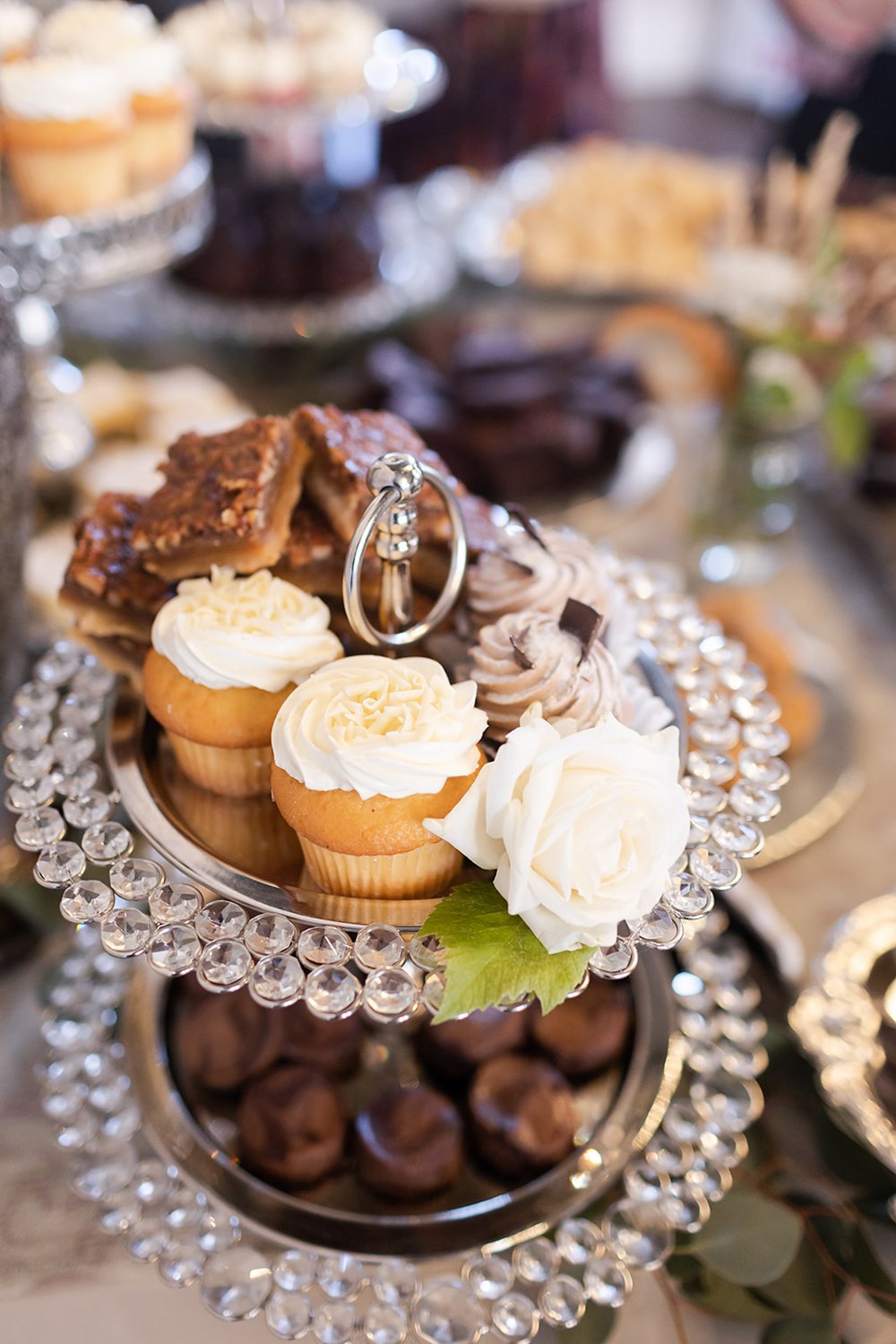cupcakes on tired tower displayed at dessert bar at wedding