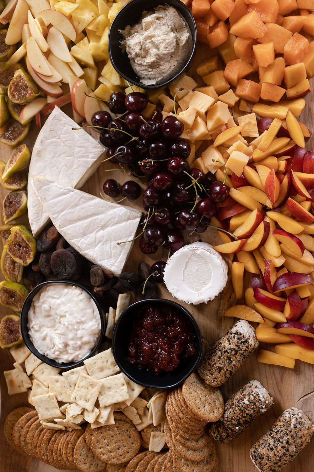cheese board with cherries apples and crackers