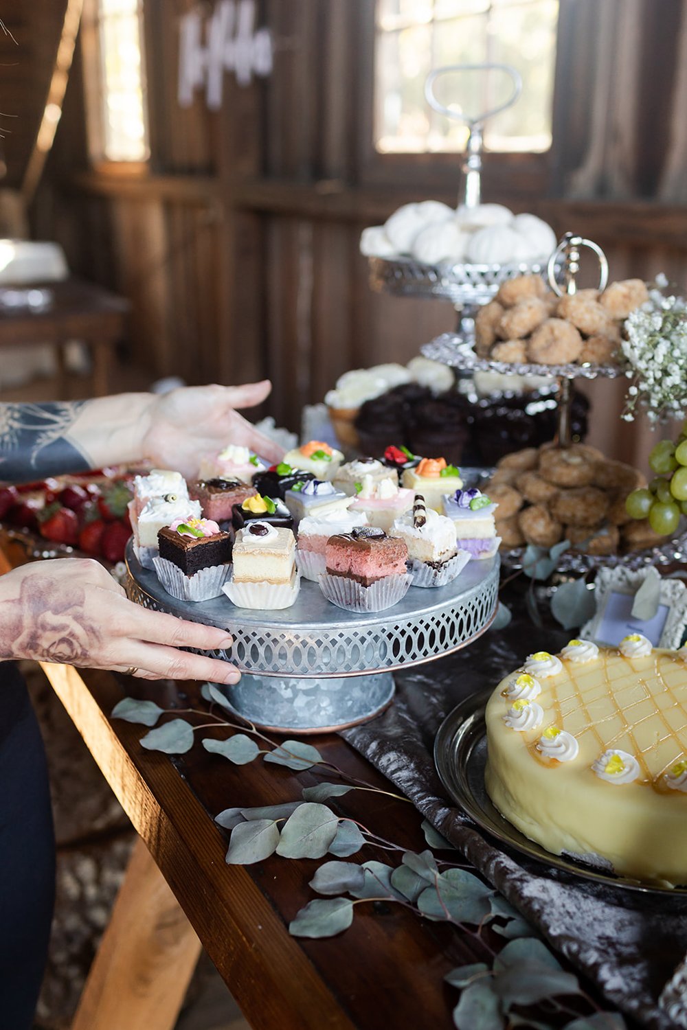woman catering employee arranging tray of desserts for wedding 