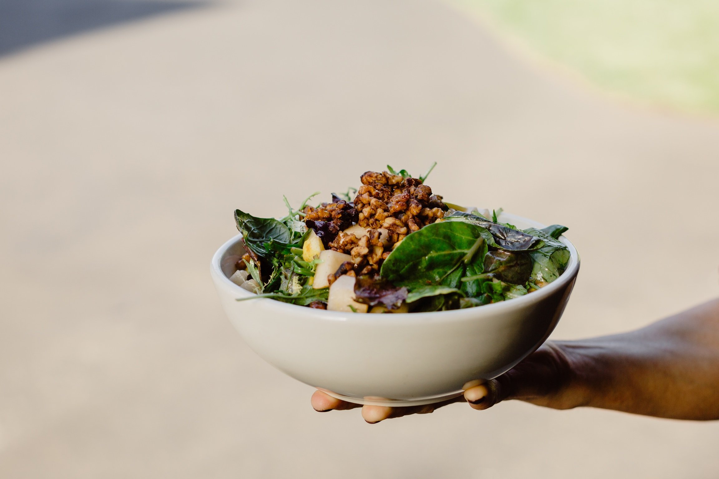 bowl of mixed greens with apples and candied pecans