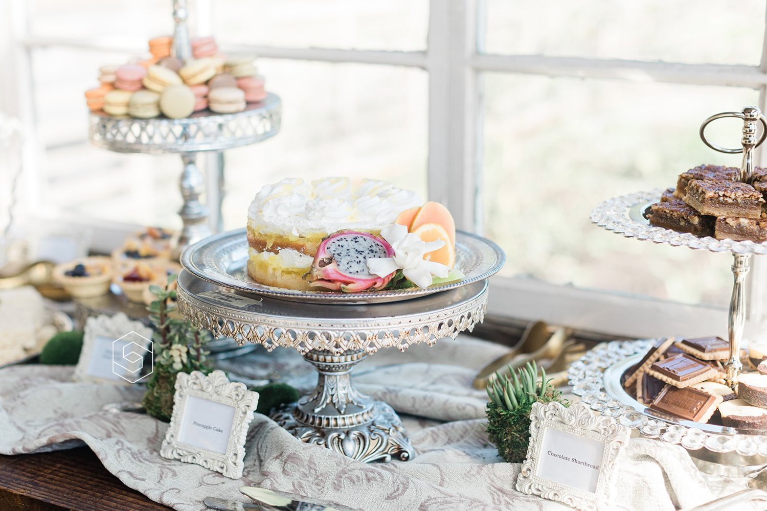 wedding dessert bar with elegant cake and french macaroons on dessert bar display 