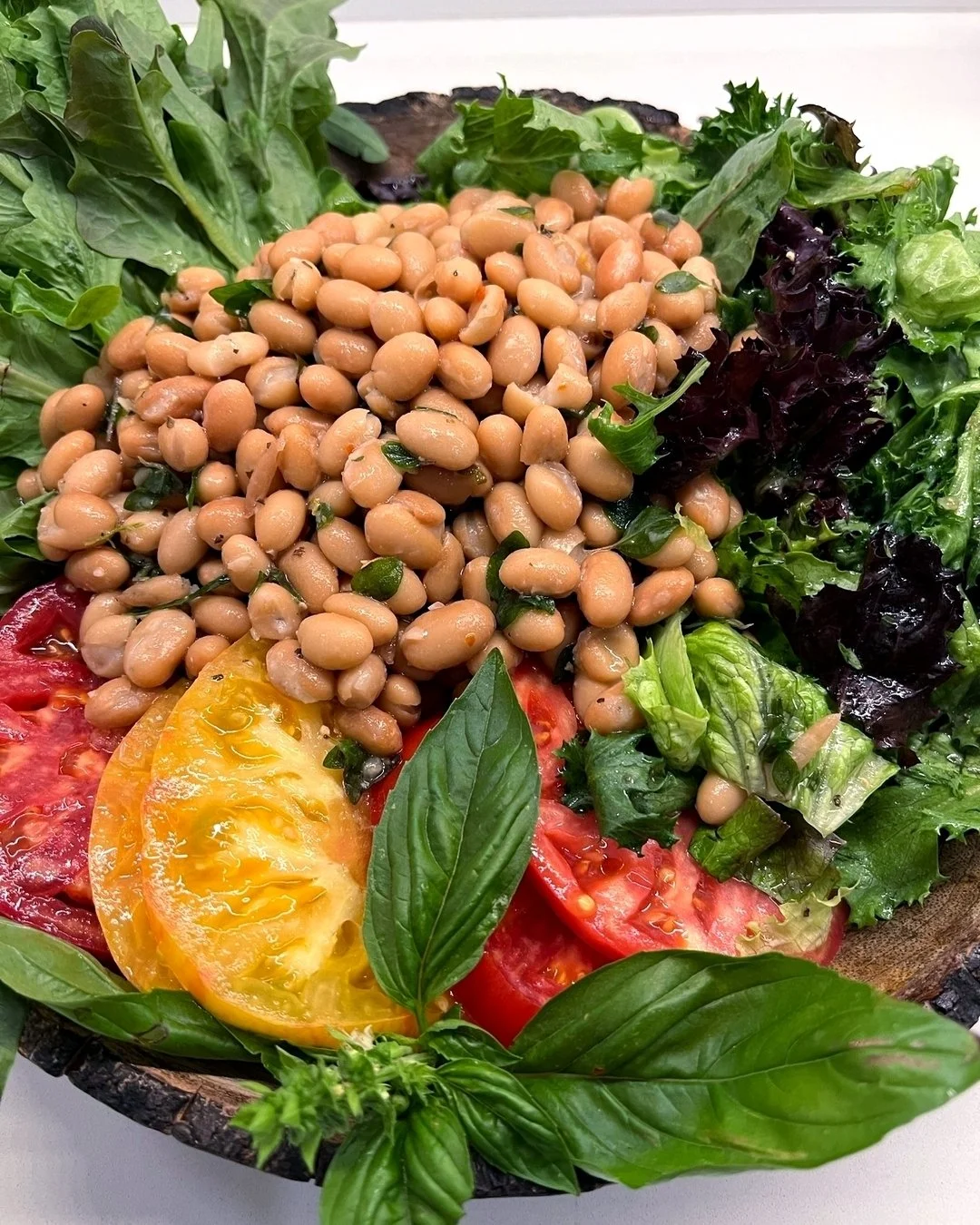 Throwback to this white bean salad perfectly paired with the last of summer's thick heirloom tomatoes. 🍅

Grown right alongside them in the garden beds was the fragrant basil that added a burst of flavor to the crisp fris&eacute;e greens from @stone