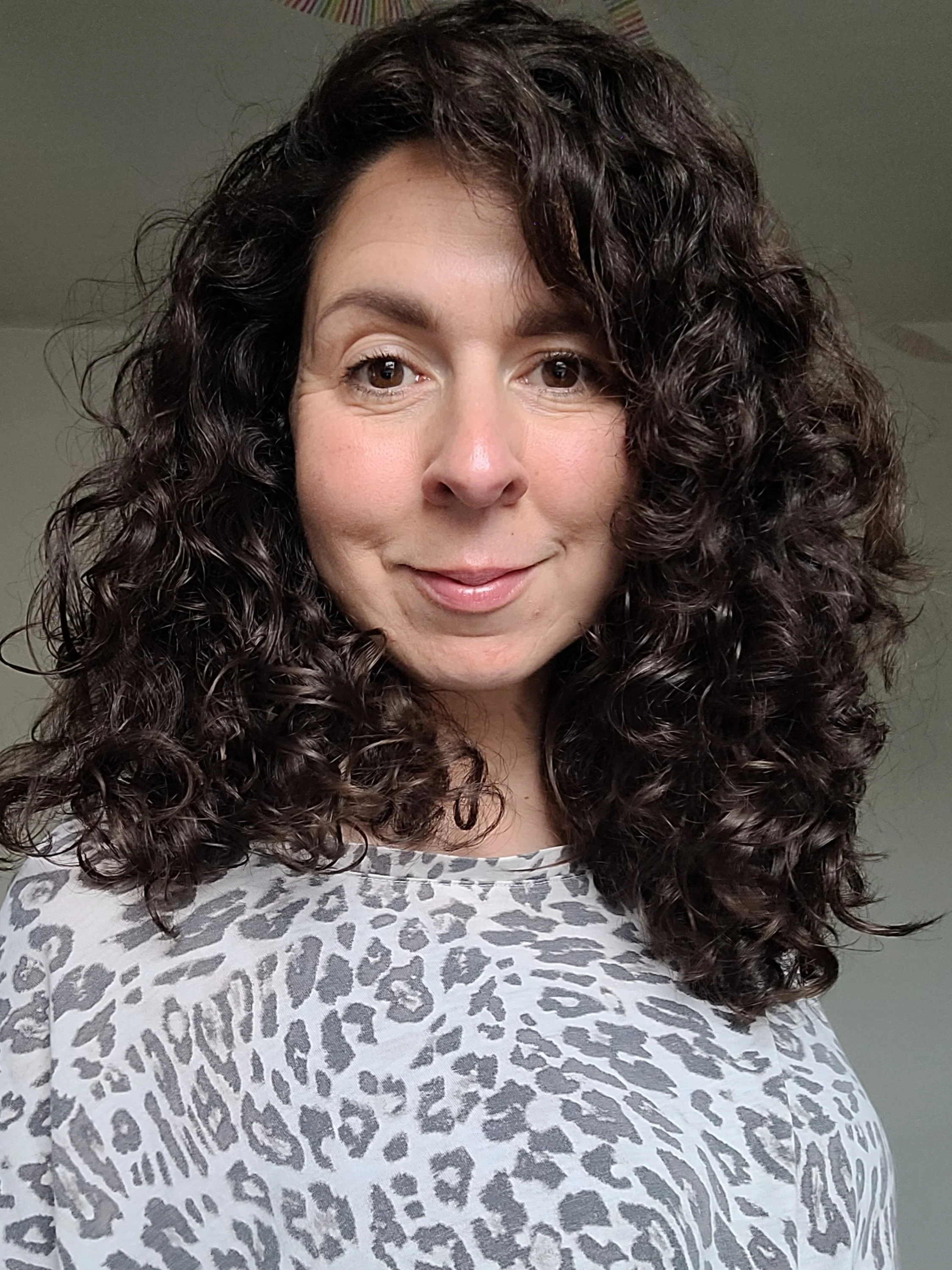 woman with dark curly hair smiles