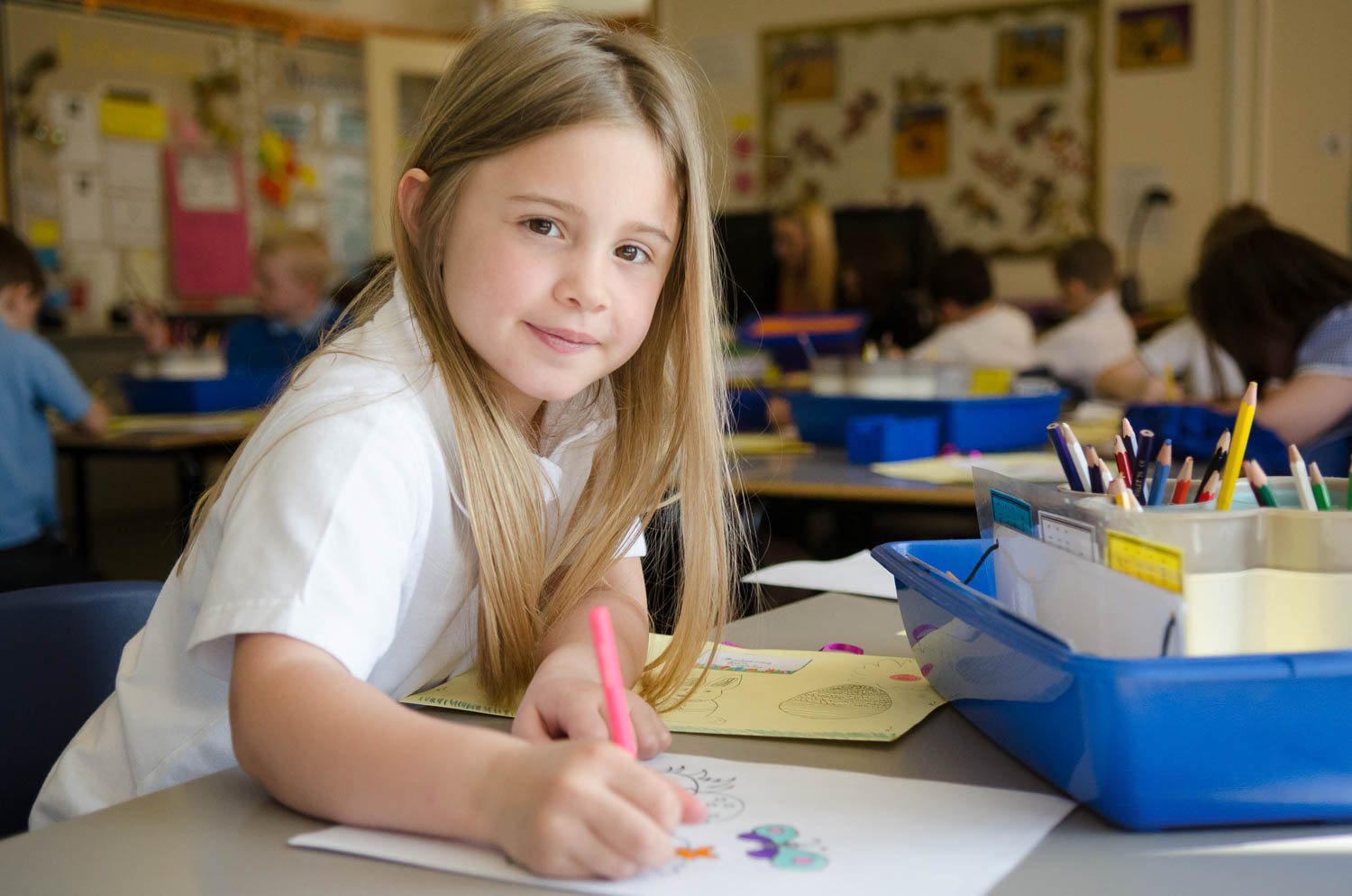 School girl at desk smiling