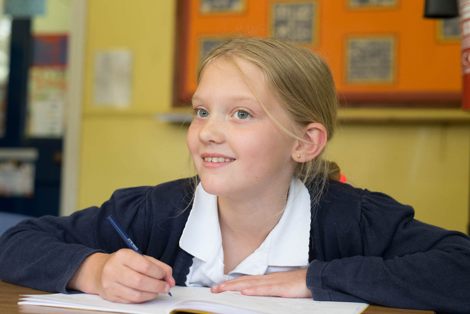 School girl at desk smiling