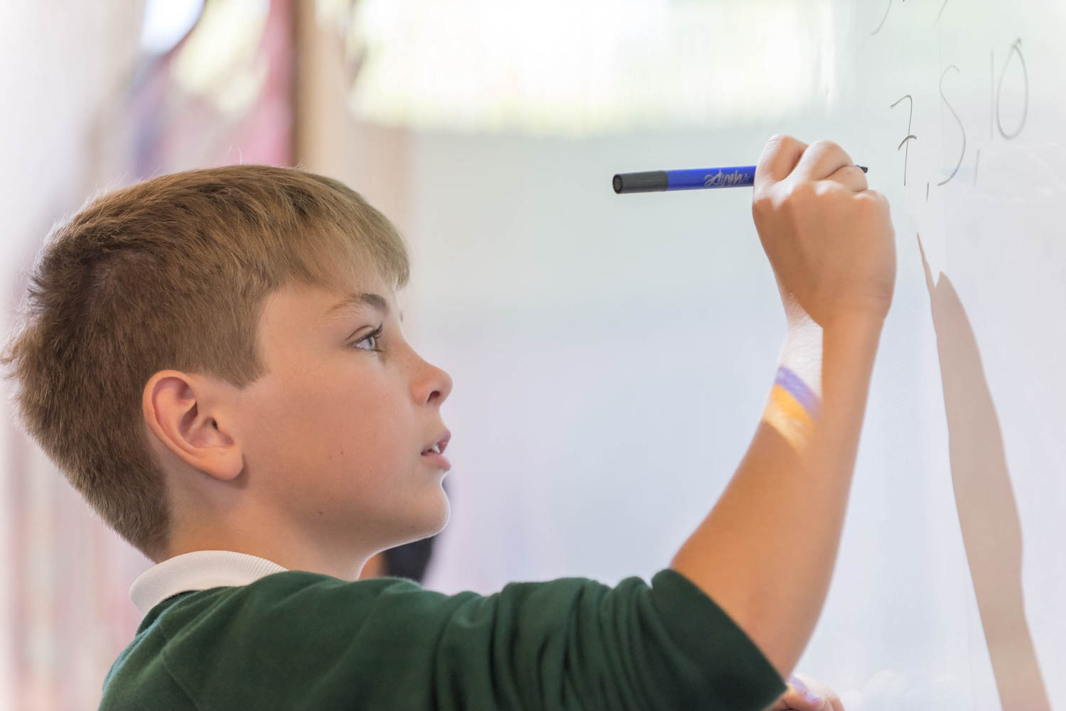 School boy writing on white board