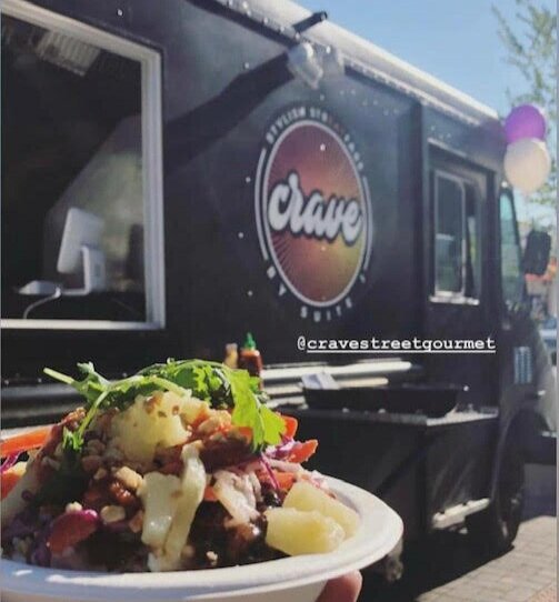  Photo:  Close view of plate of food, with food truck in the background. 