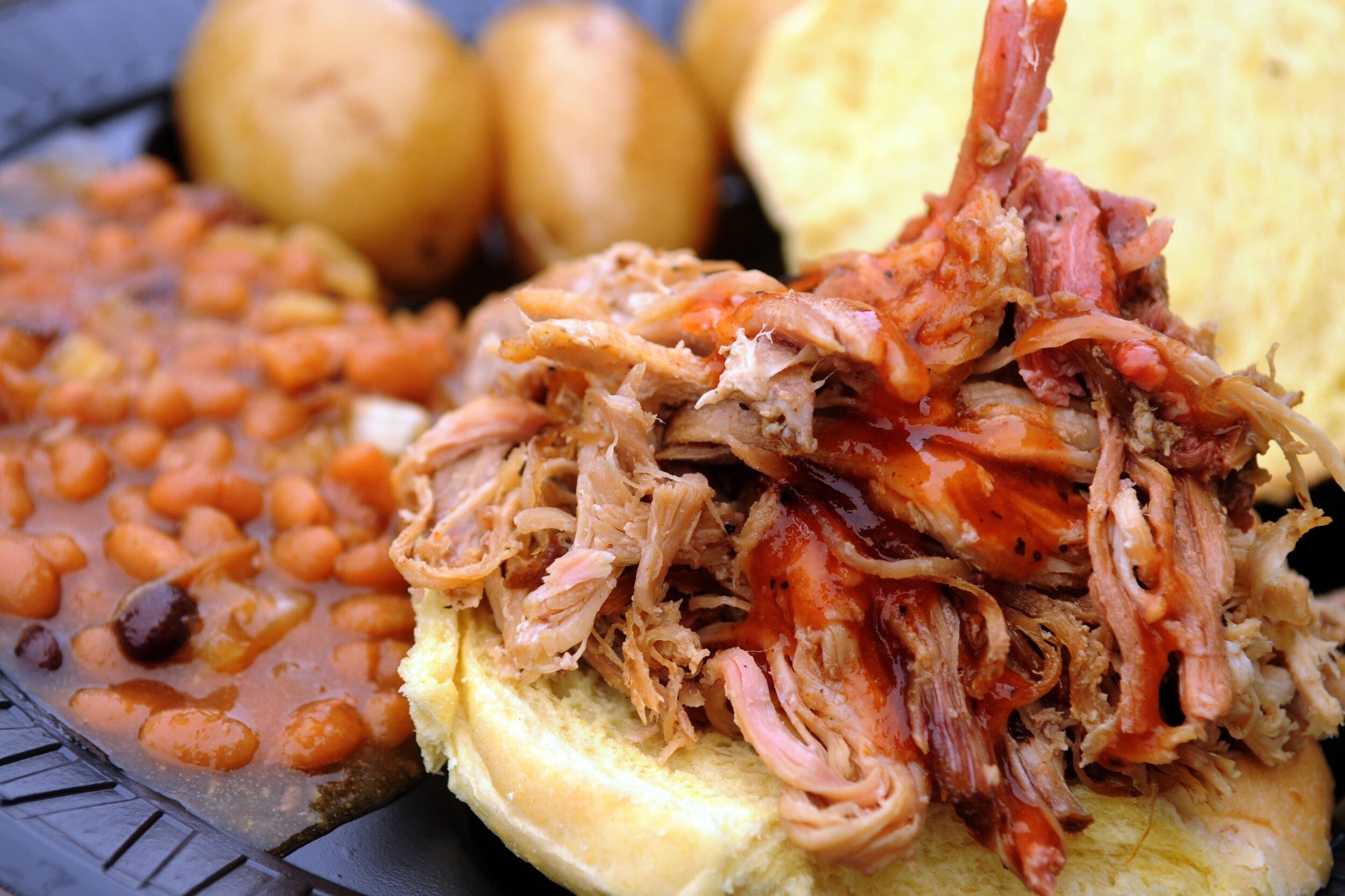  Photo:  Nice looking pulled-pork sandwich with beans and potatoes in the background.  