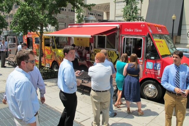  Photo:  Hungry customers, at corporate location, lined-up in front of food trucks. 