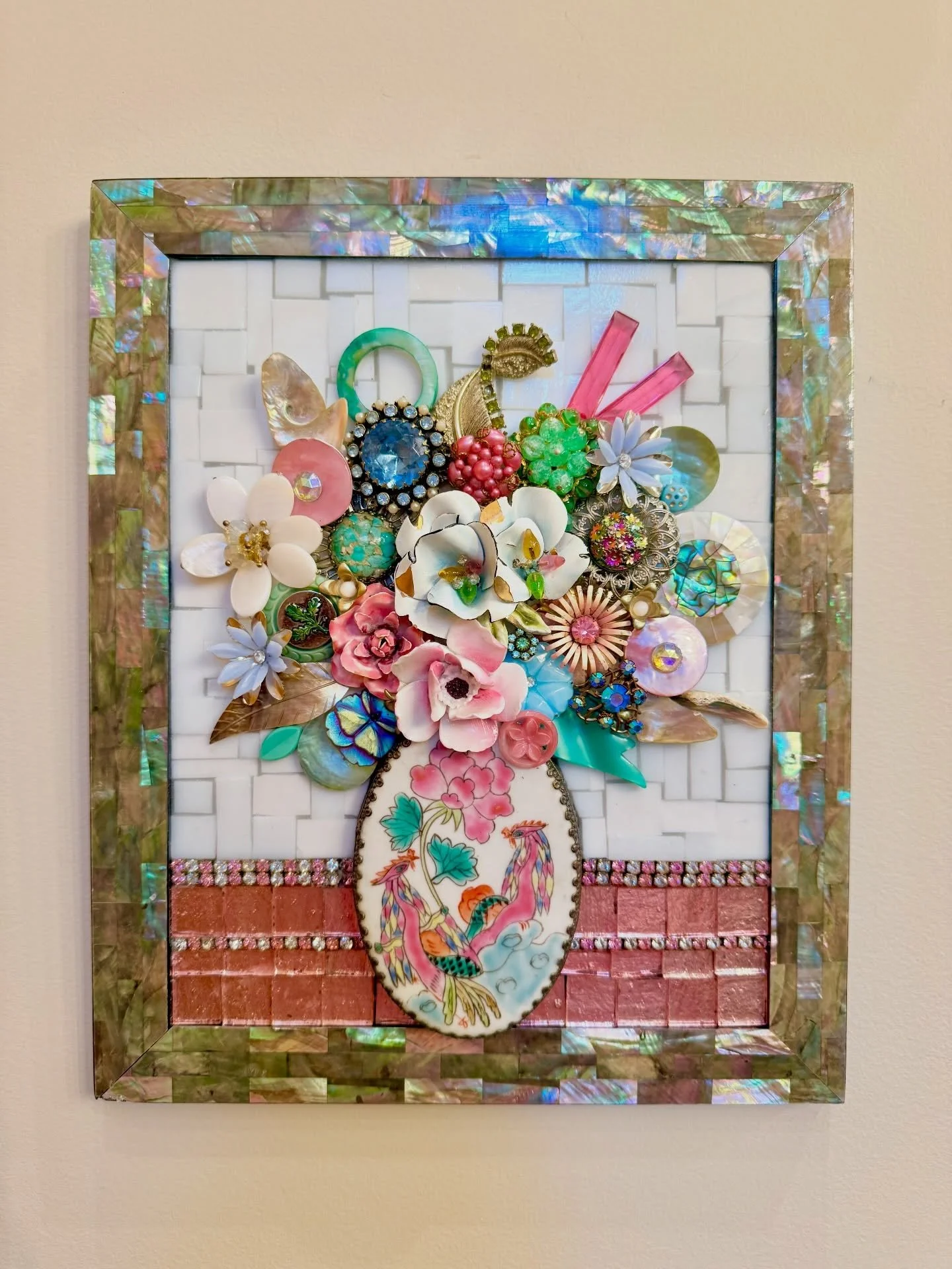 Mosaic Floral in a repurposed vintage ceramic &ldquo;vase&rdquo; with bronze casing. Glass,mirror,rhinestones,vintage jewelry parts, glass buttons, shells in an upcycled abalone frame. 11x9&rdquo;.