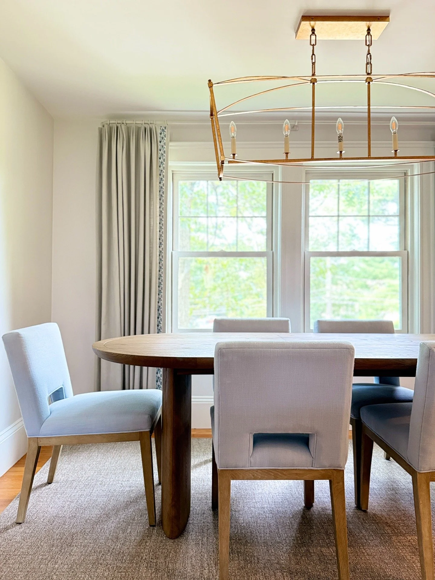 An elegant dining space designed for connection and comfort ✨ The soft palette of light blue chairs, natural wood tones, and neutral textiles creates a serene atmosphere, while the statement brass chandelier adds warmth and sophistication. A modern b