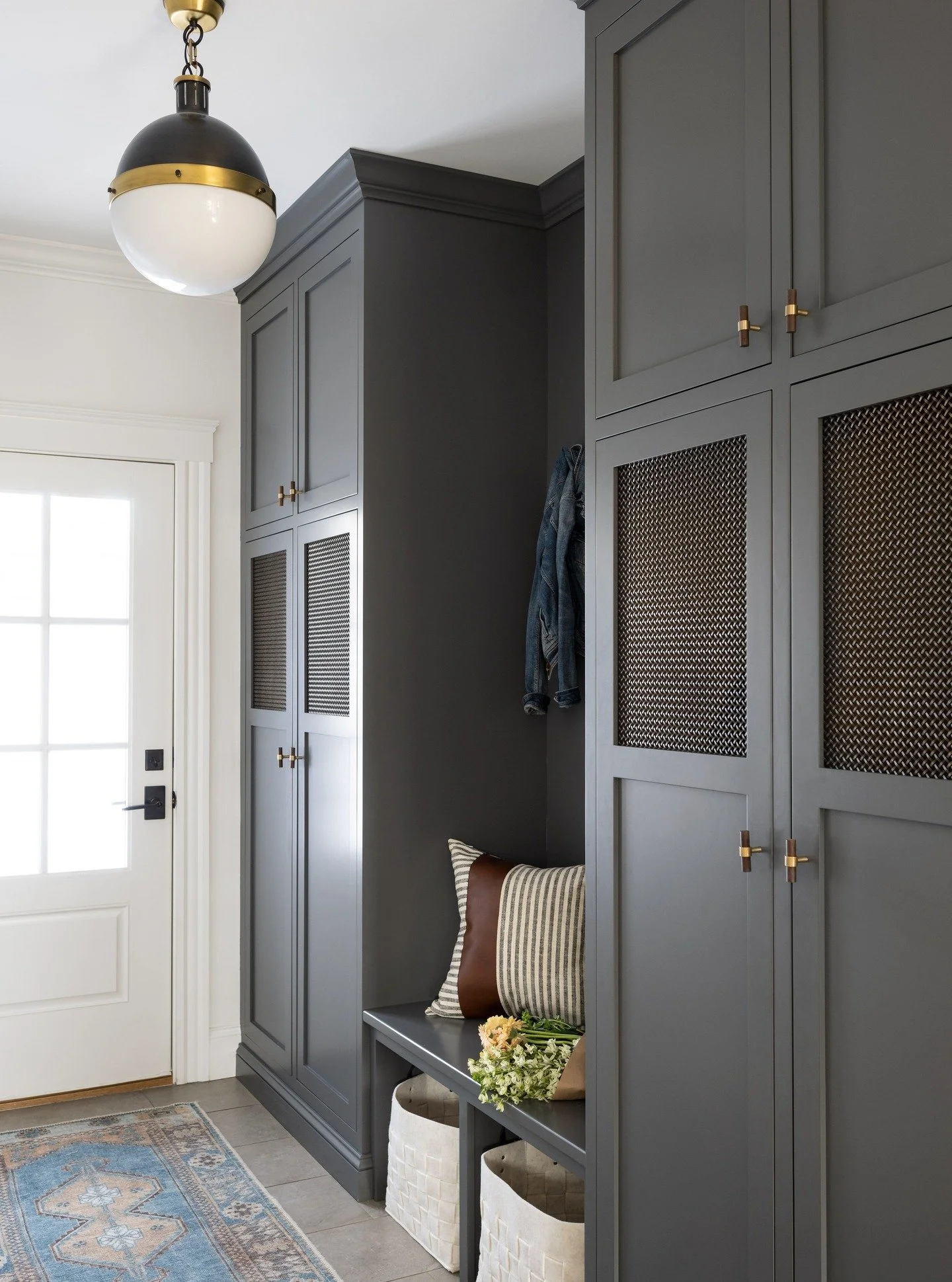Rainy days call for cozy interiors ☔️✨
This mudroom makes coming home on a rainy day a little brighter &mdash; with moody charcoal gray cabinetry, brass details, and warm textures that bring comfort and elegance to every entry. Designed for function,
