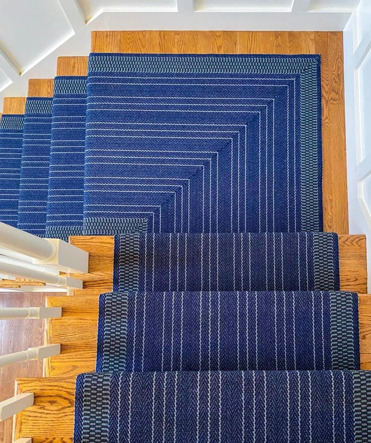 Proof that the right runner can transform a staircase into a design feature of your home.  Here we used saturated color, a crisp stripe, and a turn on the landing to make a statement.