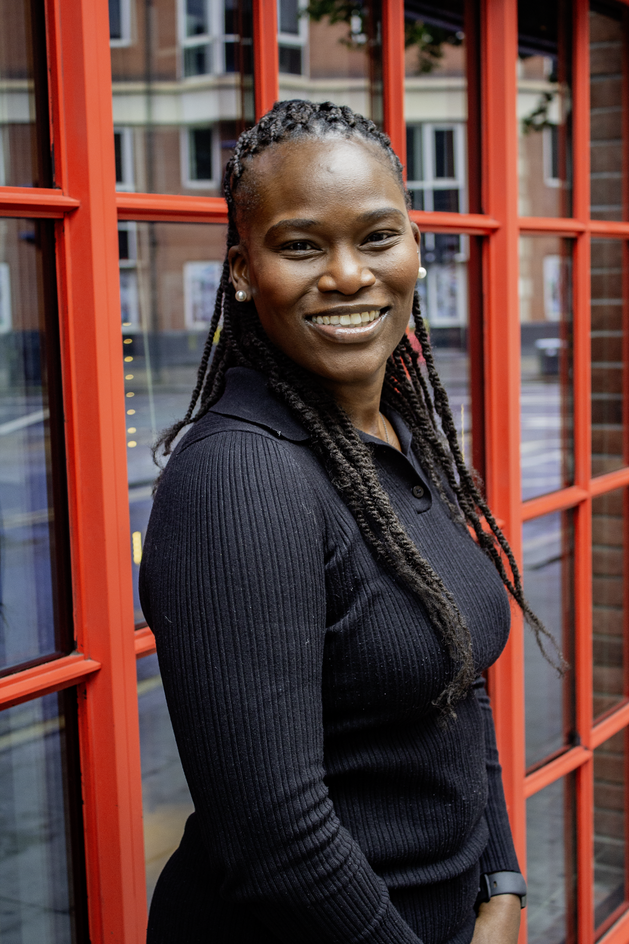 A female entrepreneur smiles at the camera on a London street