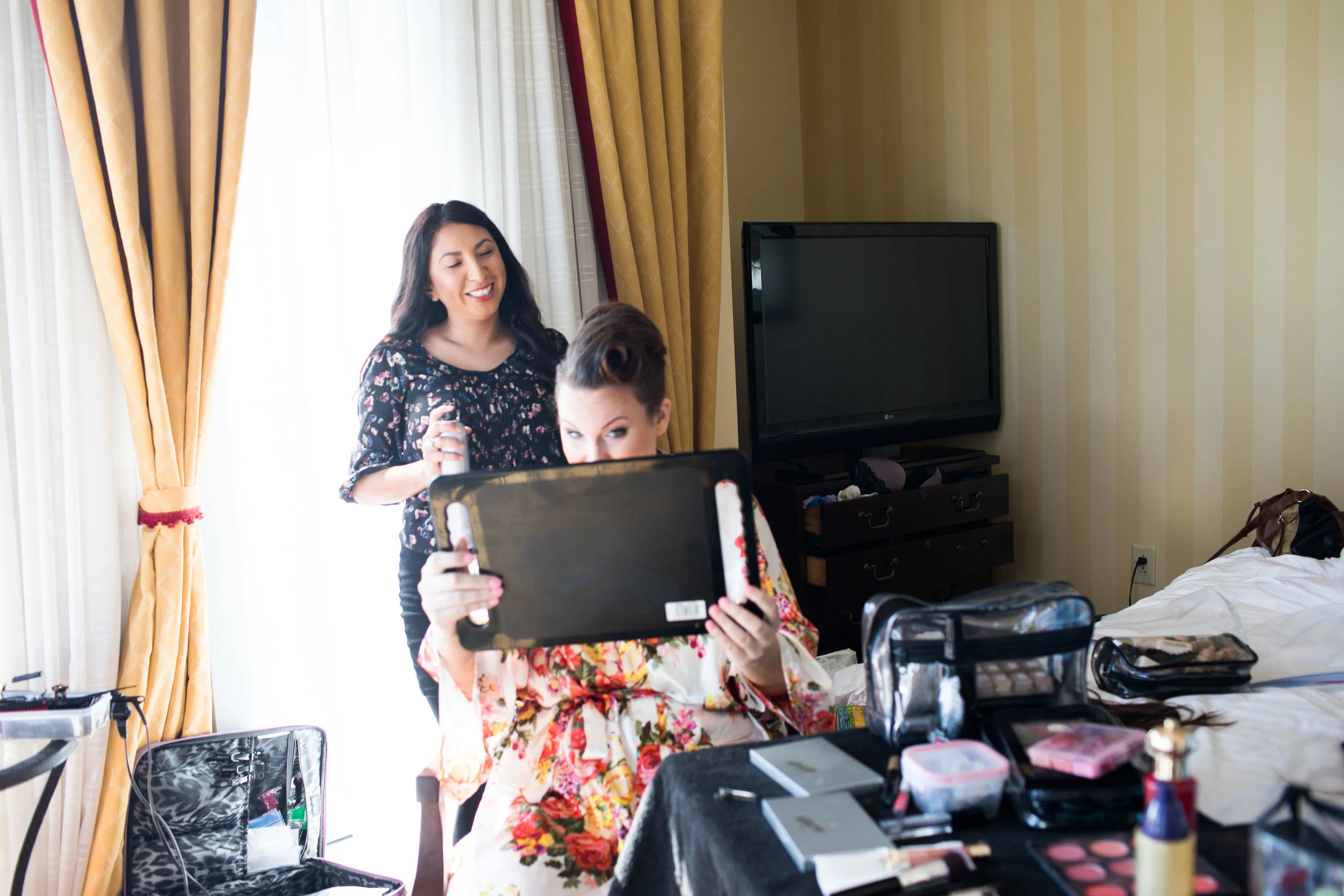 Happy bridal client admires her hair and makeup