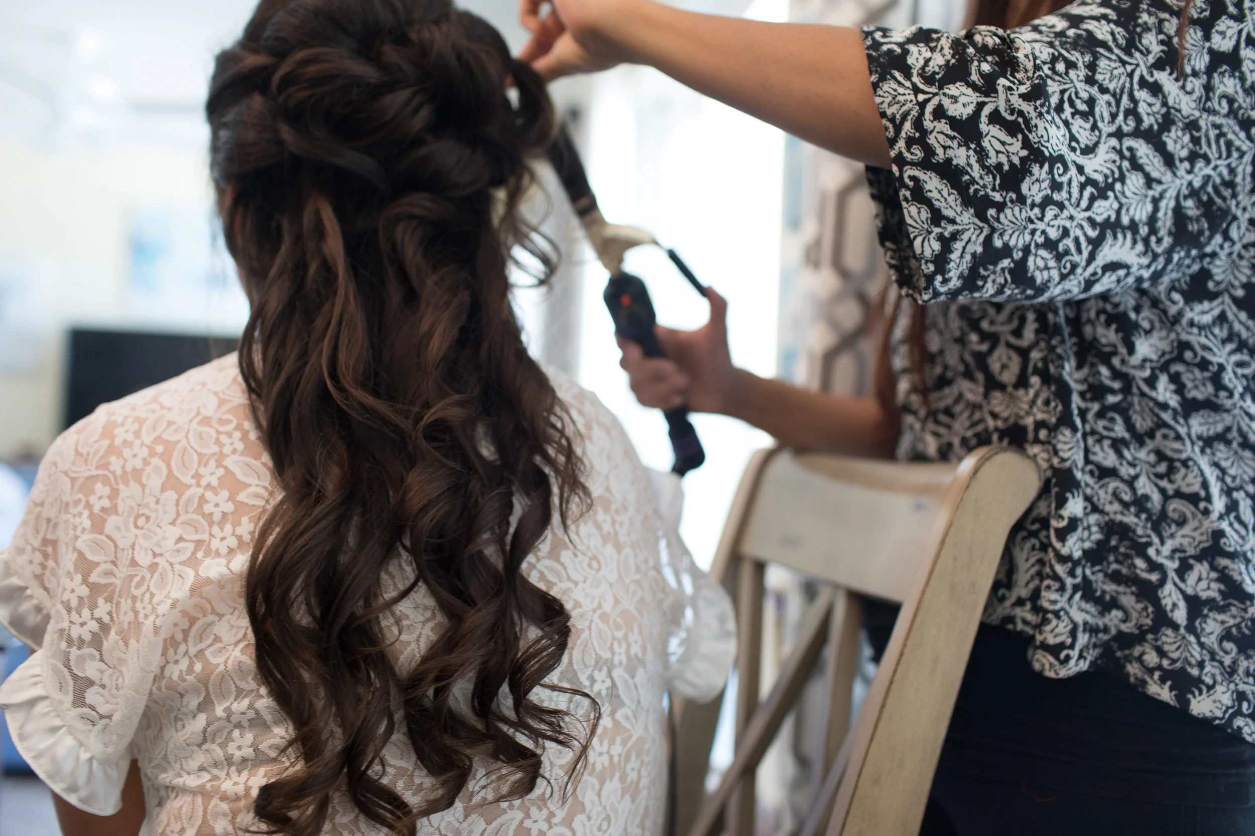 A women gets her hair curled on site for her special event