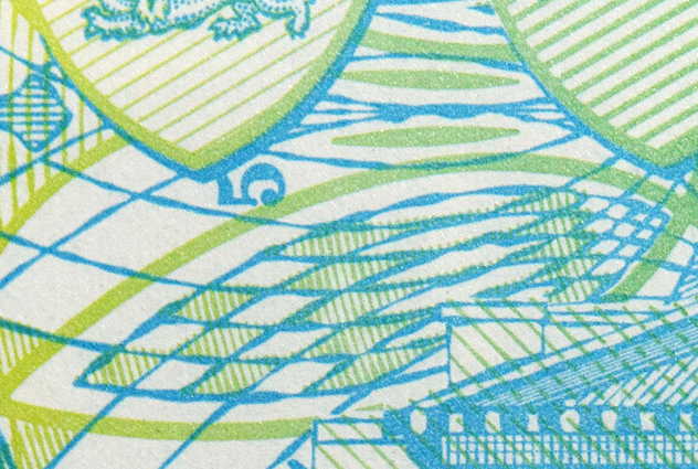 Close-up of a colorful banknote featuring intricate blue and green line patterns and geometric designs.