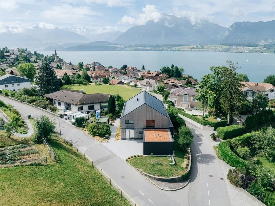 [Monolith am Thunersee]
Oberhalb des Thunersees entstand ein Einfamilienhaus mit starker Ausdruckskraft.
Die anthrazitfarbene Holzverschalung, durchbrochen von gezielt gesetzten &Ouml;ffnungen, l&auml;sst das Geb&auml;ude als monolithischen Bauk&ouml